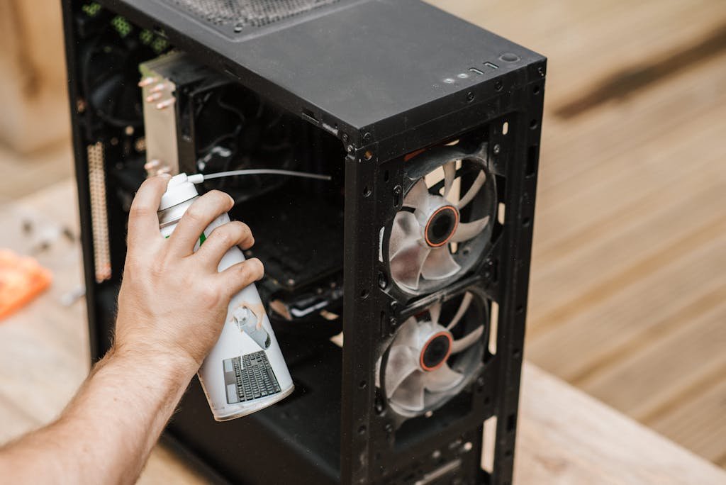 Crop unrecognizable man cleaning computer system unit